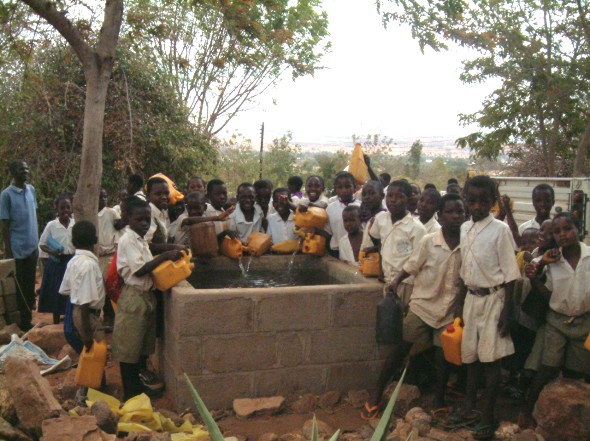 Children from Ving'hawe Primary School bring their 5ltr contributions of Water